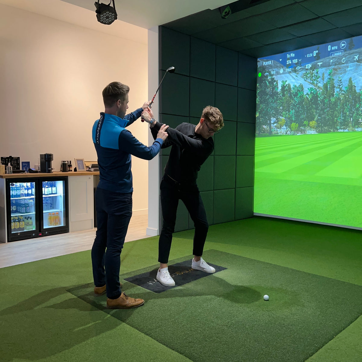 Andy Smith giving hands-on backswing coaching in the studio