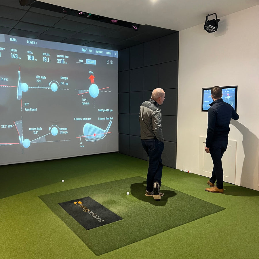 Golfers reviewing launch monitor data on the simulator screen